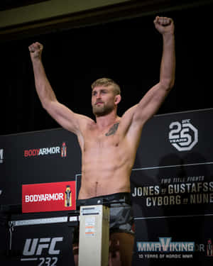 UFC拳手在體重計上高舉拳頭慶祝勝利。 — 終極格鬥冠軍賽 壁紙