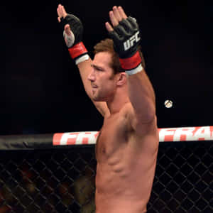 UFC拳手在八角籠內舉起雙臂慶祝勝利。 — 終極格鬥冠軍賽 壁紙