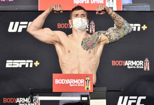 UFC拳手在稱重時戴著口罩展示手臂 — 終極格鬥冠軍賽 壁紙