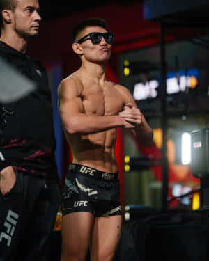 UFC拳手穿著黑色短褲和太陽眼鏡在後台自信地擺姿勢。 — 黃仁燁 壁紙