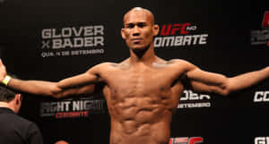 一位赤裸上身的UFC鬥士在稱重活動中張開雙臂擺姿勢。 — 終極格鬥冠軍賽 壁紙