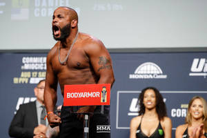 一位赤裸上身的MMA戰士在UFC稱重活動中高舉BodyArmor標誌牌咆哮。 — 終極格鬥冠軍賽 壁紙