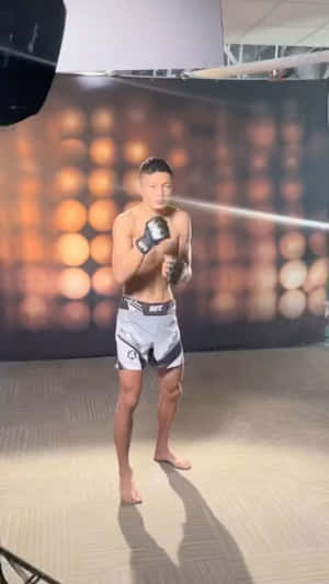 運動型戰士穿著UFC短褲和手套，在溫暖燈光的攝影棚中擺姿勢。 — 終極格鬥冠軍賽 壁紙