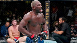 UFC戰士在濕滑的八角籠內伸出舌頭慶祝勝利。 — 終極格鬥冠軍賽 壁紙