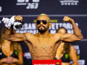 一位赤裸上身的MMA拳手在UFC稱重活動中彎曲手臂展示肌肉。 — 終極格鬥冠軍賽 壁紙