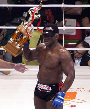 一位勝利的MMA拳手在擂台上手持獎盃。 — 運動 壁紙