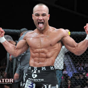 肌肉發達的拳手在MMA籠中高舉拳頭、伸出舌頭慶祝勝利。 — 終極格鬥冠軍賽 壁紙