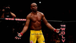 一位勝利的MMA拳手穿著黃色短褲，在八角籠中張開雙臂站立。 — 終極格鬥冠軍賽 壁紙