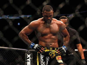 一位肌肉發達的MMA拳手穿著黑色短褲，站在UFC八角籠內，裁判在他身後。 — 終極格鬥冠軍賽 壁紙