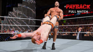 摔角手在WWE Payback賽事期間在擂台上舉起對手。 — 摔角 壁紙