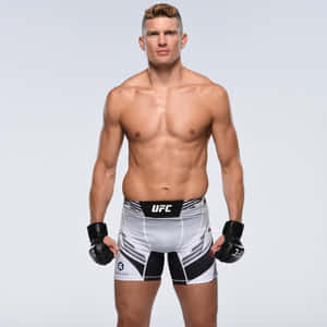 一位赤裸上身的男性綜合格鬥選手穿著UFC裝備為照片擺姿勢。 — 1:1 壁紙