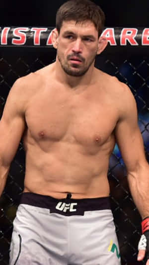 一位赤裸上身的男性MMA拳手穿著白色UFC短褲，在八角籠內。 — 終極格鬥冠軍賽 壁紙