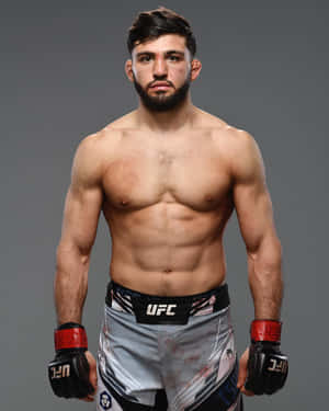 一位赤裸上身的男性MMA拳手，穿著UFC短褲和手套，為工作室肖像擺姿勢。 — 運動 壁紙