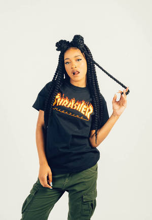 辮子年輕女性穿著Thrasher T恤和綠色工裝褲。