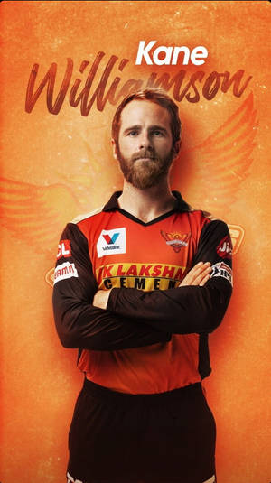 板球運動員 Kane Williamson 身穿球隊球衣，在橙色背景上雙臂交叉。 — 海德拉巴日出者 壁紙