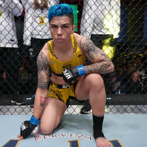 藍色頭髮的女性MMA拳手跪在UFC八角籠內。 — 終極格鬥冠軍賽 壁紙