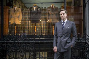 身穿灰色西裝的男士站在 Kingsman 裁縫店櫥窗外。 — 金牌特務 壁紙