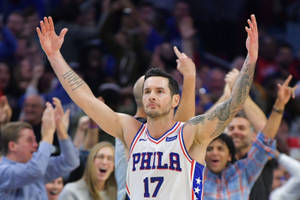 身穿白色球衣的籃球運動員在比賽中高舉雙臂慶祝。 — 酷籃球 壁紙