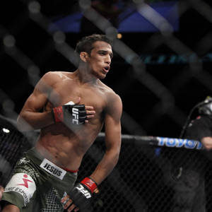 MMA選手在八角籠內將手放在胸前慶祝勝利。 — 終極格鬥冠軍賽 壁紙