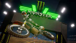 夜間體育館內在Monster Energy標誌下飛翔的越野摩托車手。 — Monster Energy 壁紙