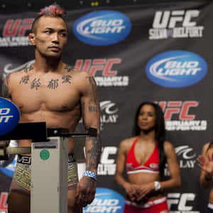 UFC拳手留著粉紅色莫西干頭和刺青，與擂台女郎一起稱重。 — 終極格鬥冠軍賽 壁紙