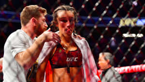 一位瘀傷的女性MMA拳手在比賽後於籠中被一名男子安慰。 — 高解析度 壁紙