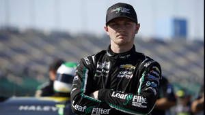 NASCAR車手穿著賽車裝備在賽道上交叉雙臂站立。 — 人物 壁紙