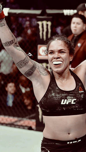 女MMA拳手在UFC八角籠內舉臂慶祝勝利。 — 終極格鬥冠軍賽 壁紙