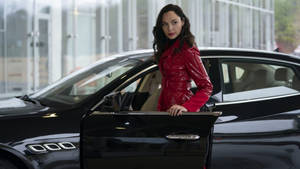 身穿紅色外套的女性在玻璃建築內靠著黑色豪華汽車。 — 好看汽車 壁紙