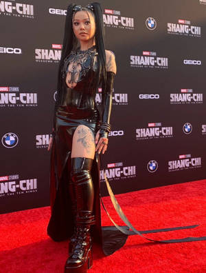 身穿黑色乳膠服裝的女性在 Shang-Chi 首映式紅地毯上擺姿勢。 — 哥德美學 壁紙