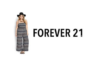 身穿圖案連身褲和黑色帽子的女性，站在Forever 21標誌文字旁。