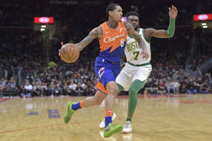 克里夫蘭騎士隊球員在NBA比賽中運球越過波士頓塞爾提克隊防守球員。