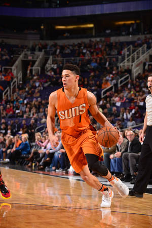 籃球運動員在職業比賽中在人群面前運球。 — Devin Booker 壁紙