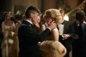 身穿燕尾服的男士在優雅派對上溫柔觸碰女士的臉龐 — 湯瑪斯·謝爾比 壁紙