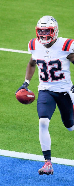 身穿愛國者隊球衣的美式足球員在球場上帶球奔跑。 — NFL 美式足球 壁紙