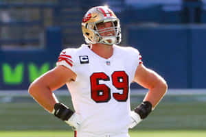 身穿白色69號球衣的美式足球員站在球場上，雙手叉腰。 — NFL 美式足球 壁紙