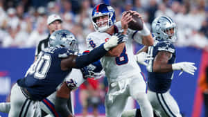 NFL四分衛在現場比賽中受到兩名防守球員的壓力。 — 運動 壁紙