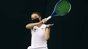 女網球選手戴著口罩和白色制服在室內揮動球拍。 — 羽球 壁紙