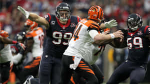 NFL美式足球運動員在比賽中行動，防守球員擒抱四分衛。 — 休士頓德州人 壁紙
