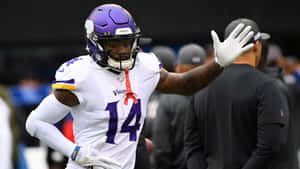 身穿維京人球衣的美式足球員向人群揮手。 — Stefon Diggs 壁紙