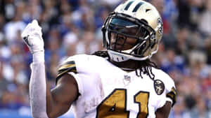 美式足球員在日間比賽中在球場上慶祝勝利。 — Alvin Kamara 壁紙