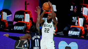 密爾瓦基公鹿球員在NBA季後賽比賽中投籃，防守球員在附近。 — The Krew 壁紙