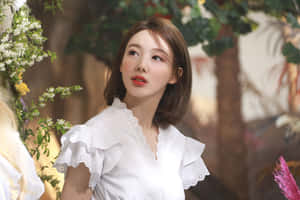 身穿白色襯衫的女性，被鮮花和綠葉環繞。 — 飛天小女警 壁紙