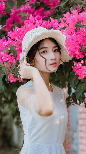 年輕女子身穿白色連衣裙和草帽，被粉紅色九重葛包圍。 — 粉色花朵 壁紙