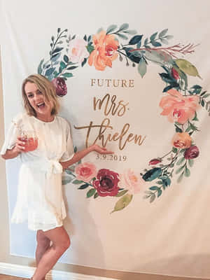 身穿白色連衣裙的女性在婚禮背景前拿著飲料大笑。 — 婚紗 壁紙
