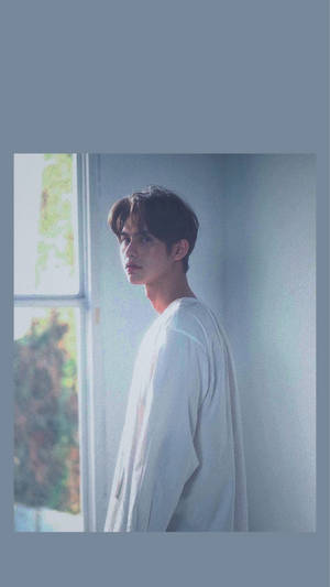 身穿白襯衫的年輕男子站在窗邊，柔和自然光 — 明亮 壁紙