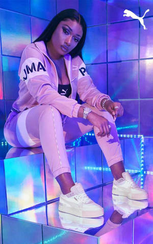 身穿粉紅色 Puma 服裝的女性在發光平台上擺姿勢。 — 噗卡 壁紙