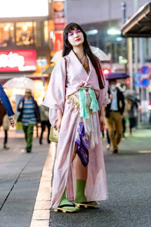 身穿粉紅色和服、綠色襪子和涼鞋的女性，在雨夜的東京街頭。 — 日本武士 壁紙