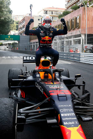 F1車手在街道賽道上坐在賽車上，於日落時分慶祝。