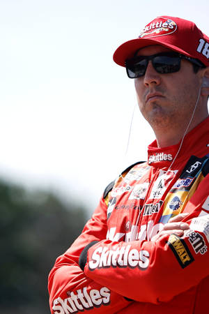 身穿紅色Skittles制服的NASCAR車手在戶外交叉雙臂。 — 運動 壁紙